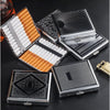 A collection of decorative metal cigarette storage boxes in silver and orange, some open and stacked on a dark surface.