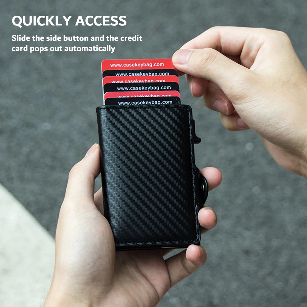 A hand holds a black carbon fiber RFID pop-up card holder with credit cards automatically popping out.