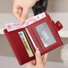 A hand is opening a maroon PU leather bifold wallet to show an ID window and credit cards.
