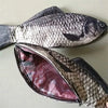A silver and black fish-shaped pencil case and coin purse shown open to reveal the interior.
