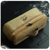 A beige fabric organizer case with a zipper and leather strap is shown on a dark surface.