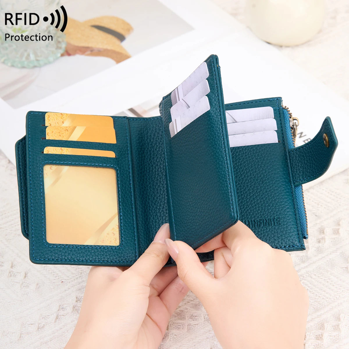 A dark teal RFID blocking bi-fold card holder wallet is shown being held open to display cards.