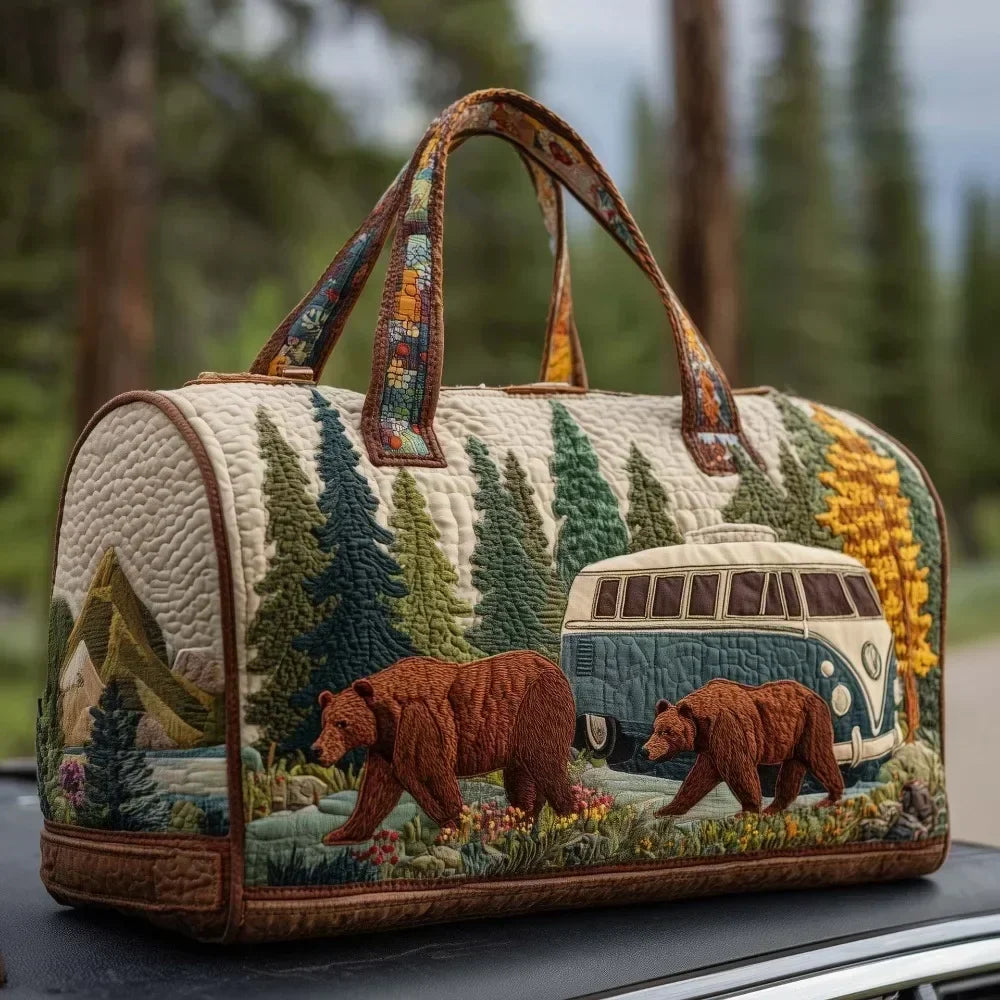 A quilted travel duffle bag featuring a nature scene with evergreen trees and two bears.