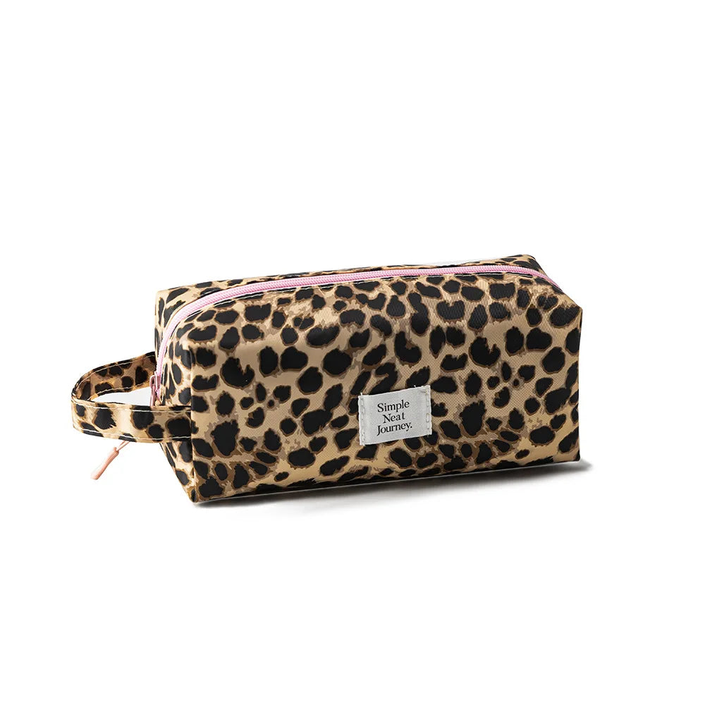 A leopard print travel makeup organizer bag with a pink trim and a small tag.