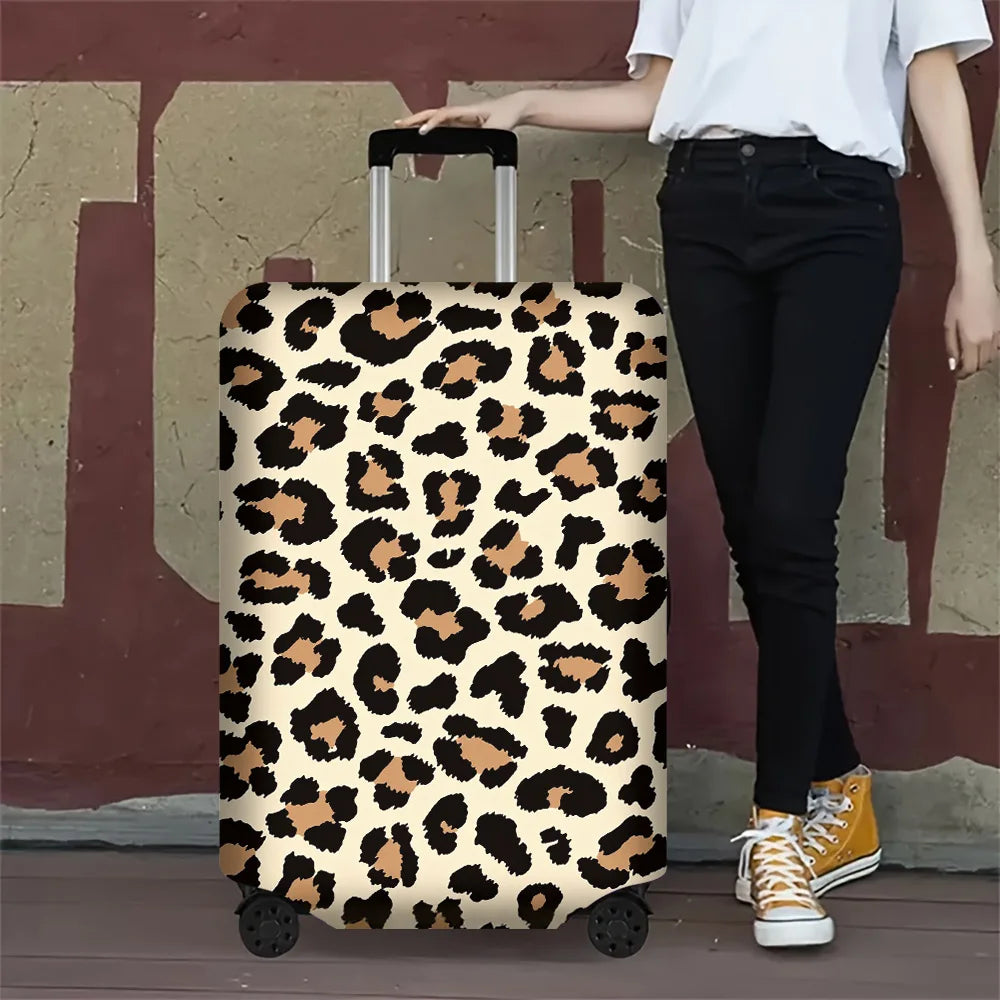 A person is holding a leopard print protective luggage cover for travel bags against a reddish-brown wall.