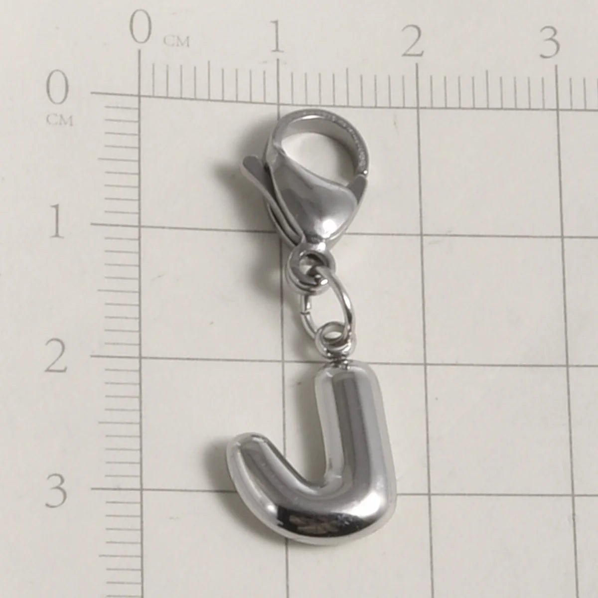 Silver stainless steel alphabet letter charm shaped like the letter J with a lobster clasp