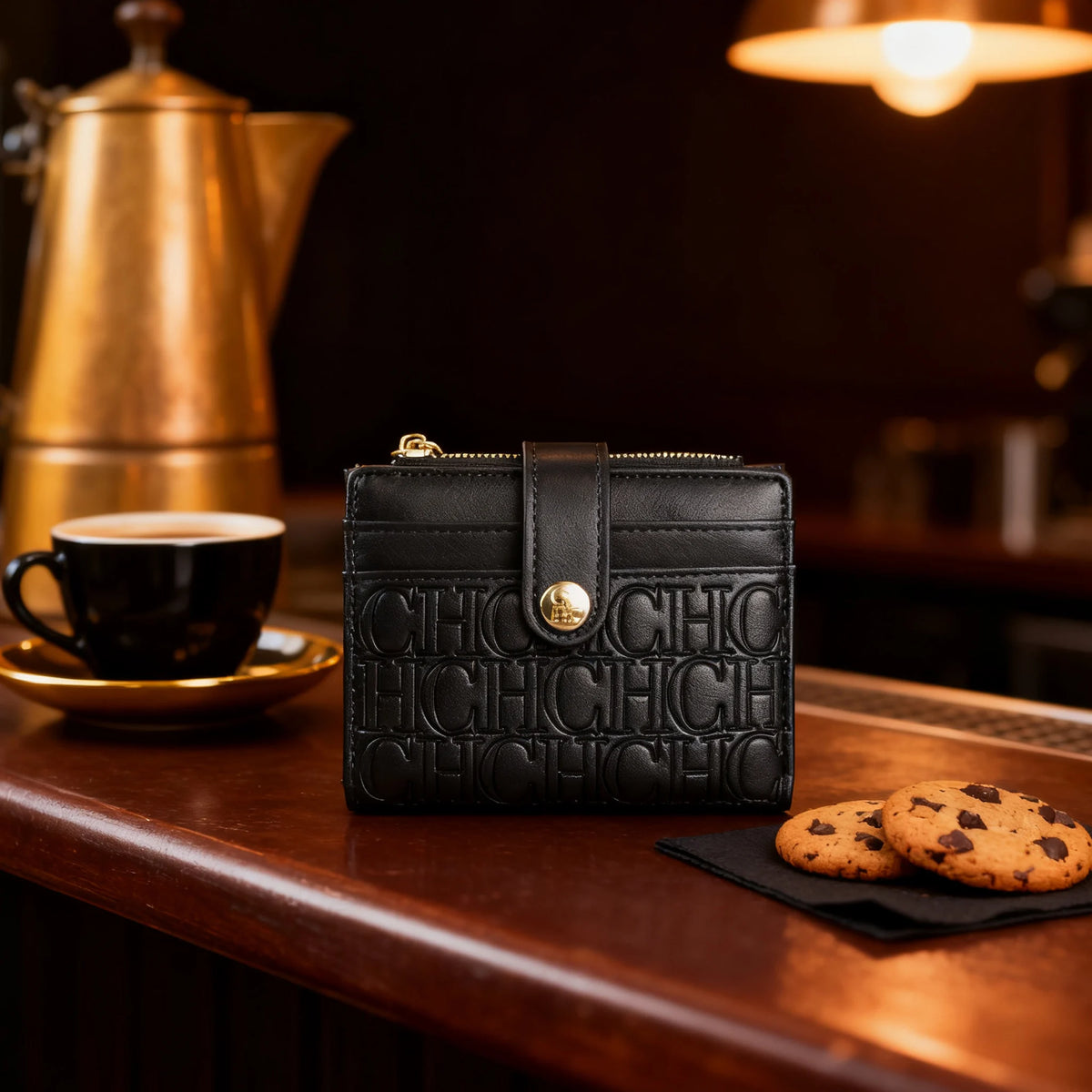 A black classic square folding wallet resting on a wooden counter next to a cup and a brass teapot.