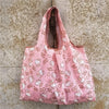 Pink reusable shopping bag with a white pattern featuring cute animal faces