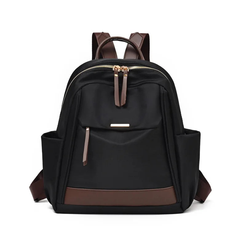 A black nylon travel backpack with brown accents and a zippered top.