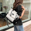 Eine Frau hält einen schwarzen Rucksack mit einem weißen Nylon-Bucket-Totebeuteldesign.