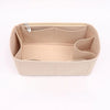 A light beige felt purse organizer with internal compartments and a zipper closure.