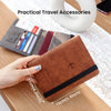 A brown leather passport holder with a flap and stitching is shown next to various travel accessories on a wooden surface.