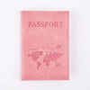 A pink leather passport holder with the word PASSPORT printed on it and a world map design.