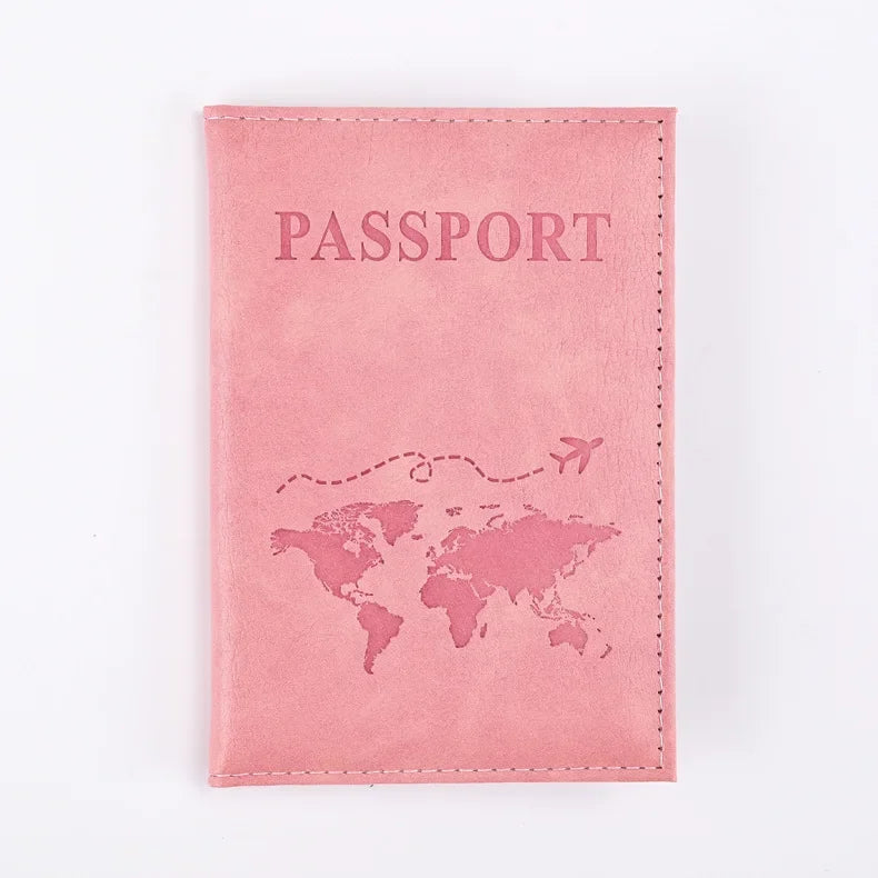 A pink leather passport holder with the word PASSPORT printed on it and a world map design.
