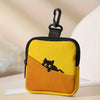 A yellow fabric coin purse shaped like a cat sitting on an orange slope with a black zipper.