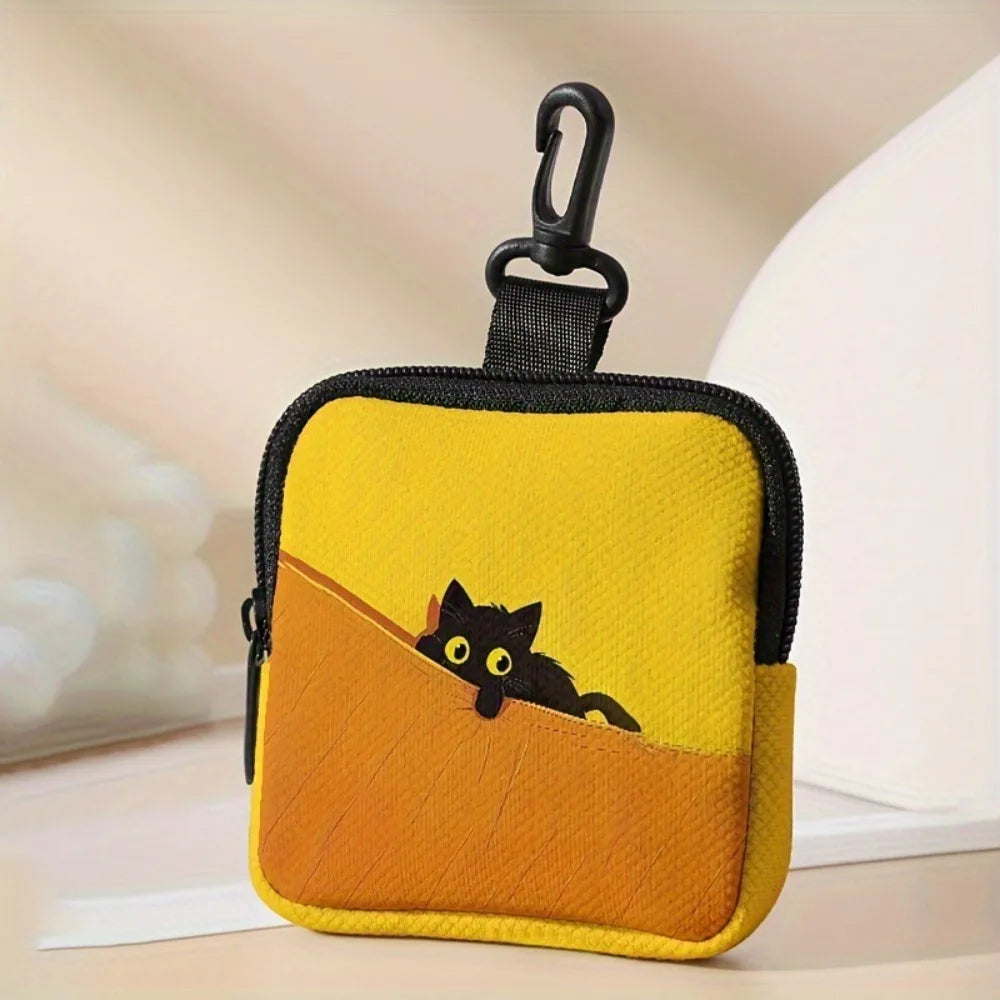 A yellow fabric coin purse shaped like a cat sitting on an orange slope with a black zipper.