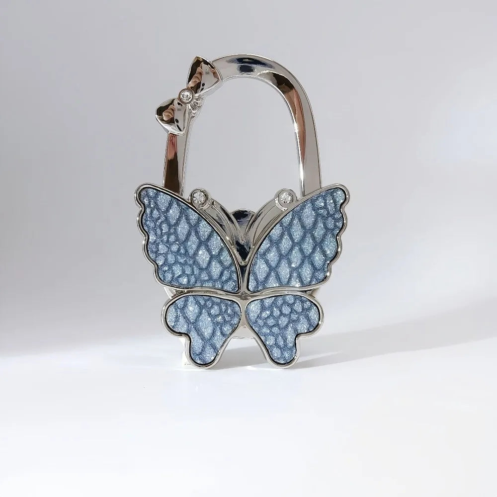 Silver foldable butterfly shaped handbag hook with detailed texture