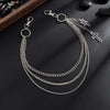 Silver punk star chain belt with pearl accents displayed on a dark surface.