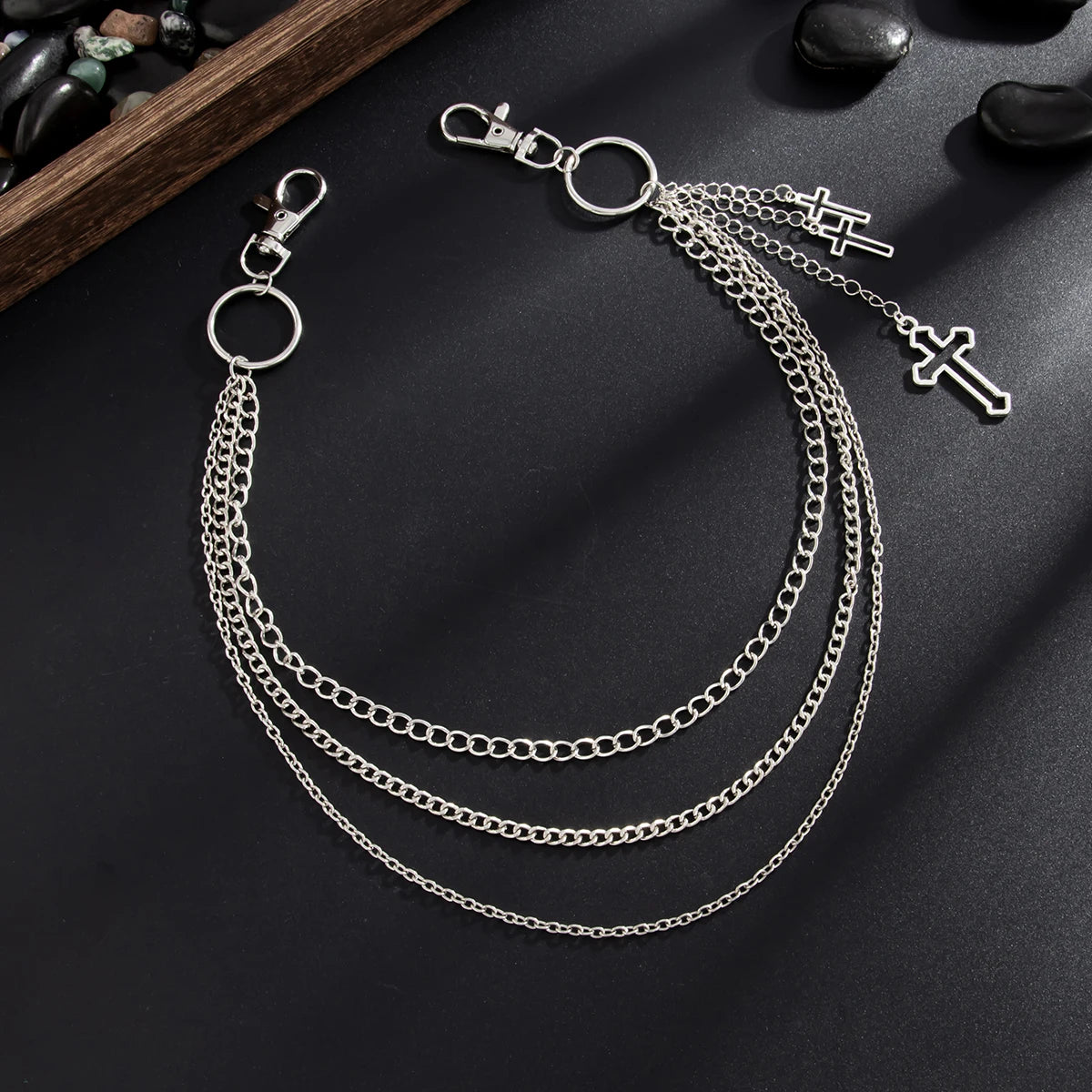 Silver punk star chain belt with pearl accents displayed on a dark surface.