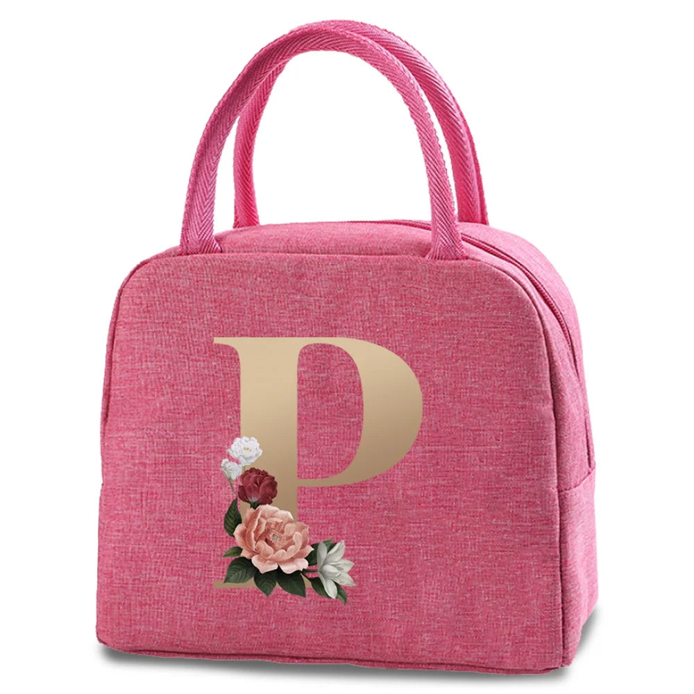 A pink insulated canvas lunch bag with a gold letter P and floral embroidery on the front.