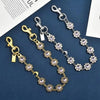 Gold and silver crystal petal keychain with rhinestone charm displayed on a dark blue background.