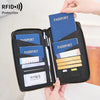 A black passport wallet is shown open, displaying several passports and credit cards, with a hand holding the item.