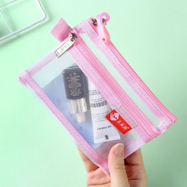 A pink double-layer zipper pouch containing a small electronic device and cards, held in a hand.