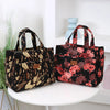A pair of black cloth tote bags with floral patterns displayed on a white surface.