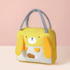A yellow insulated thermal picnic lunch bag shaped like a dog, featuring light gray straps and a white face.