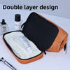 Zwei-lagiges Kosmetiktasche in Orange und Schwarz mit Pinsel und Flasche.