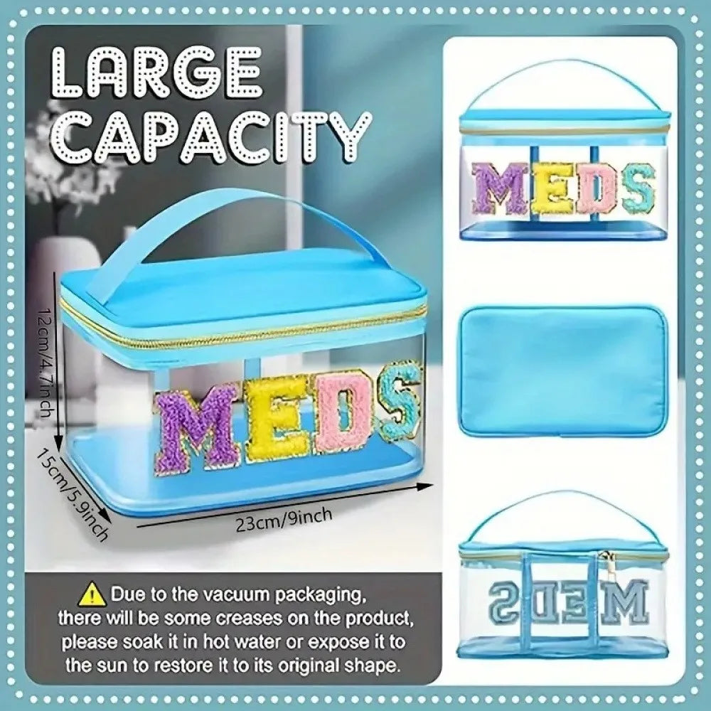 A clear plastic toiletry bag with a lid and embroidered letters MEDS in purple, yellow, and green thread.