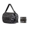 A black and gray camouflage patterned foldable nylon storage bag with a handle.