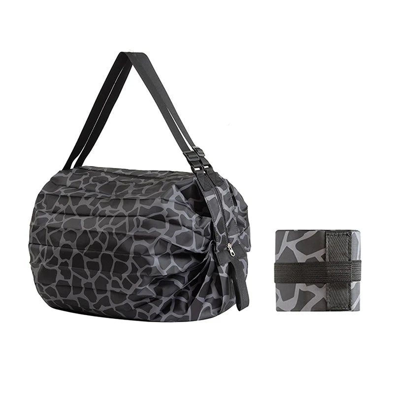 A black and gray camouflage patterned foldable nylon storage bag with a handle.