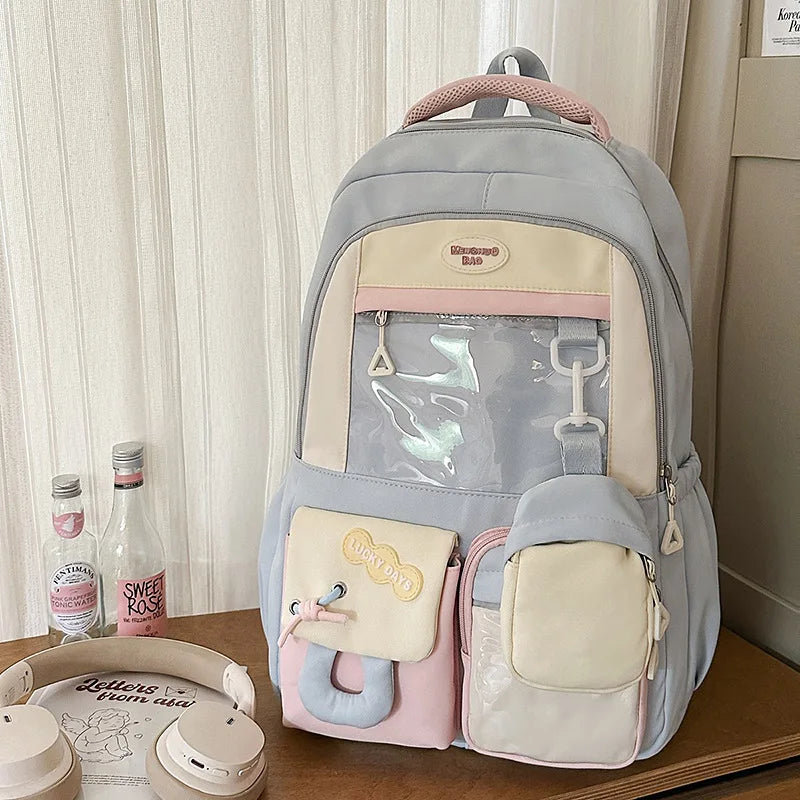 A light gray and pink Kawaii Harajuku backpack with multiple compartments for school supplies.