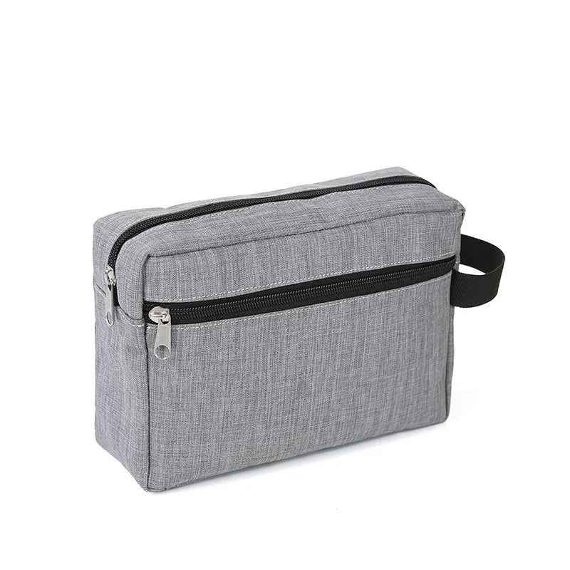 A gray zippered travel cosmetic bag with a black trim and a black strap.