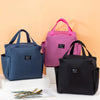 Three insulated canvas tote bags in navy blue, pink, and black are displayed on a white surface.
