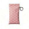 A pink polka dot eyeglass pouch with a silver keychain attached.