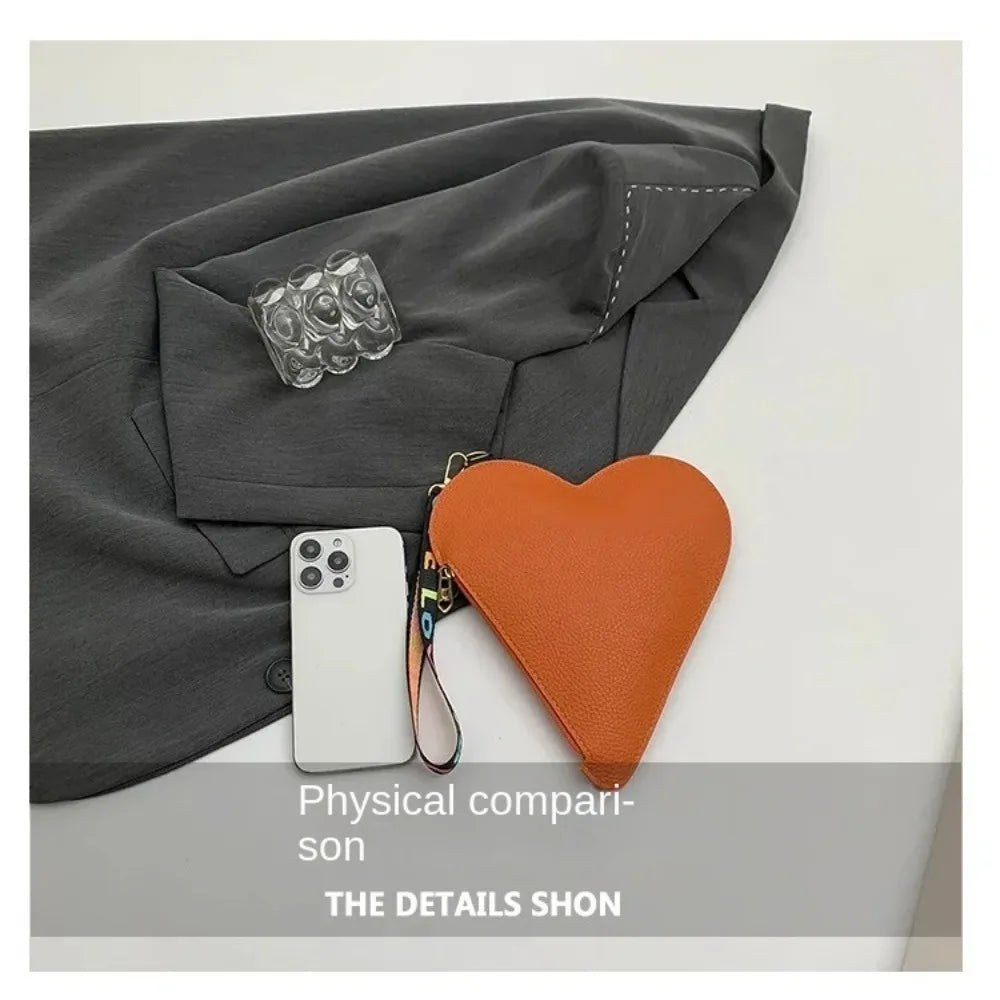 Cartera de monedas naranja con forma de corazón junto a un blazer gris, ilustrando una comparación física de los detalles.