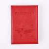 A red leather passport holder with the word PASSPORT embossed on the cover and a world map design.
