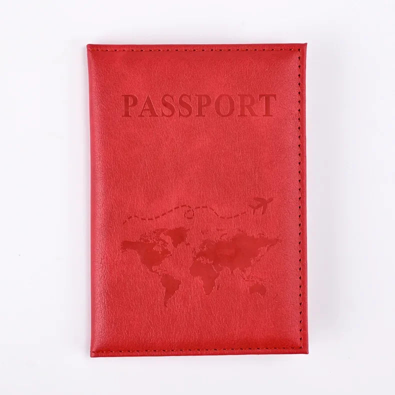 A red leather passport holder with the word PASSPORT embossed on the cover and a world map design.