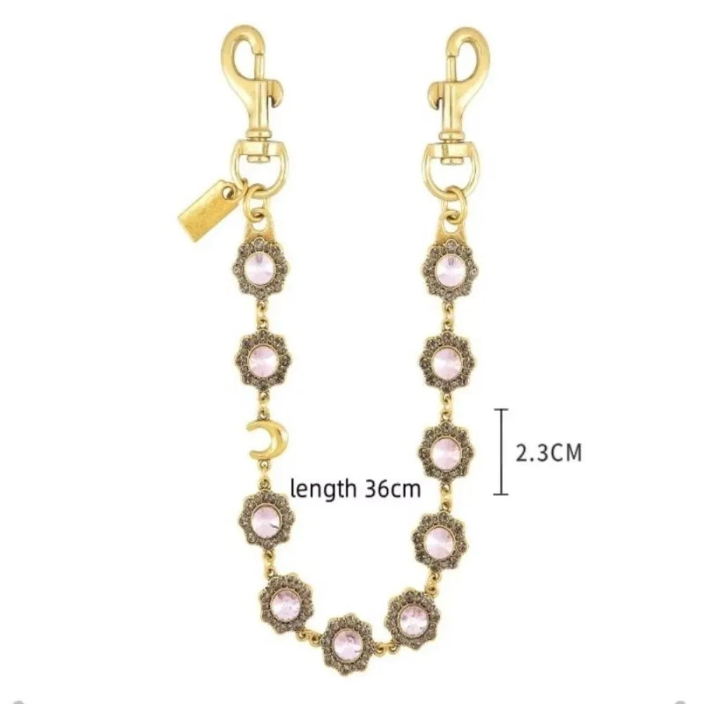 Gold-toned crystal petal keychain with rhinestone charm and a long chain.