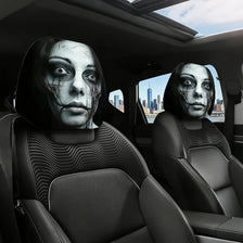 A set of spooky ghost face car headrest covers featuring distressed, ghostly faces on black leather seats.