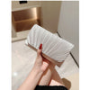 A hand holds a silver chain shoulder clutch bag with pleated fabric against a light background.