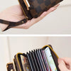 A close-up of a brown faux leather accordion card holder wallet with gold accents and a checkered pattern, being held by a ha