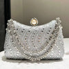 Silver rhinestone evening clutch featuring a decorative pearl closure and intricate stonework.