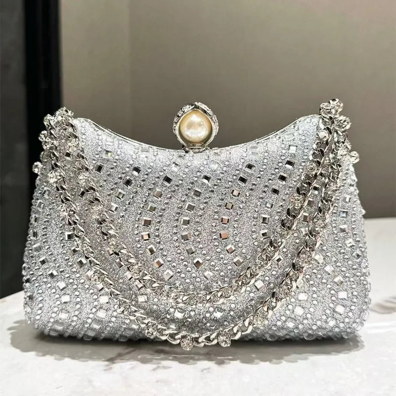 Silver rhinestone evening clutch featuring a decorative pearl closure and intricate stonework.