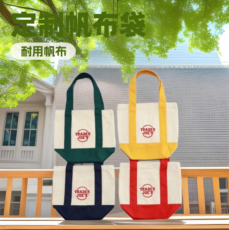 Three canvas bags in green, white, and navy colors displayed outdoors against a building backdrop.