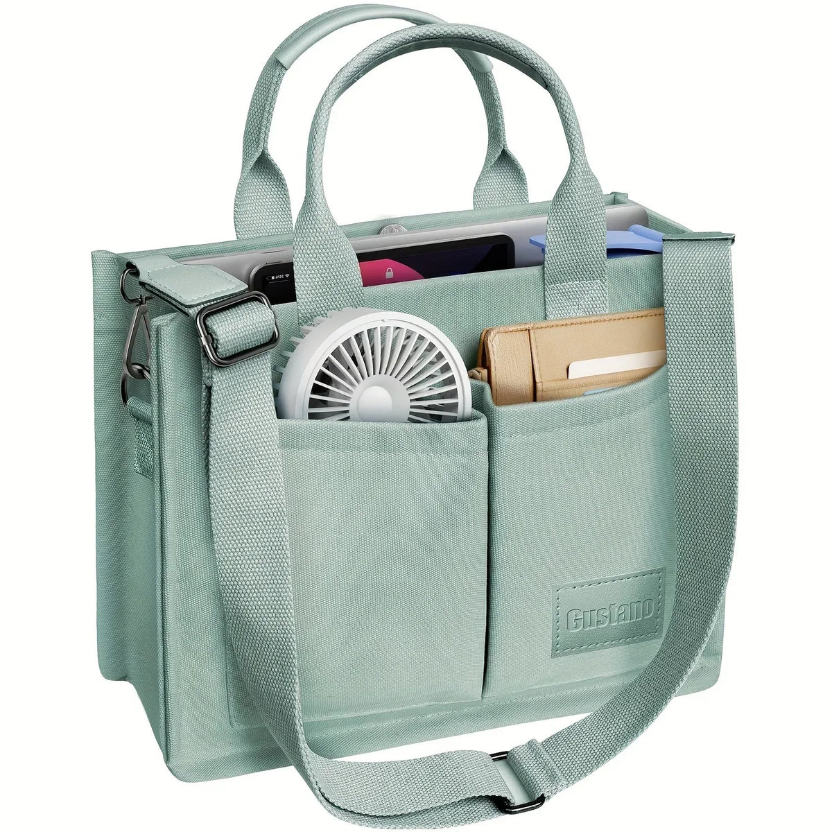 A light mint green canvas tote handbag with leather accents and a mesh fan inside.