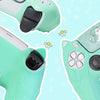 A close-up view of a light green silicone grip cover for a PS5 controller with cat paw print texture.