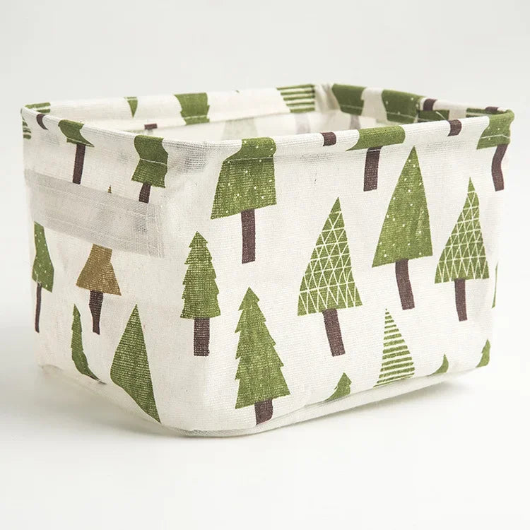 A natural linen storage basket with a white background and green pine tree pattern.